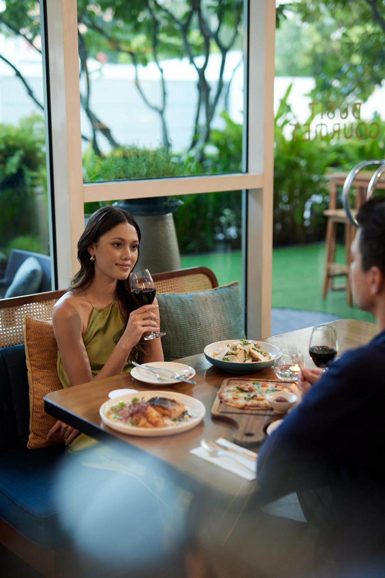 曼谷拉差达姆里都喜套房酒店 外观 照片 A woman drinking wine