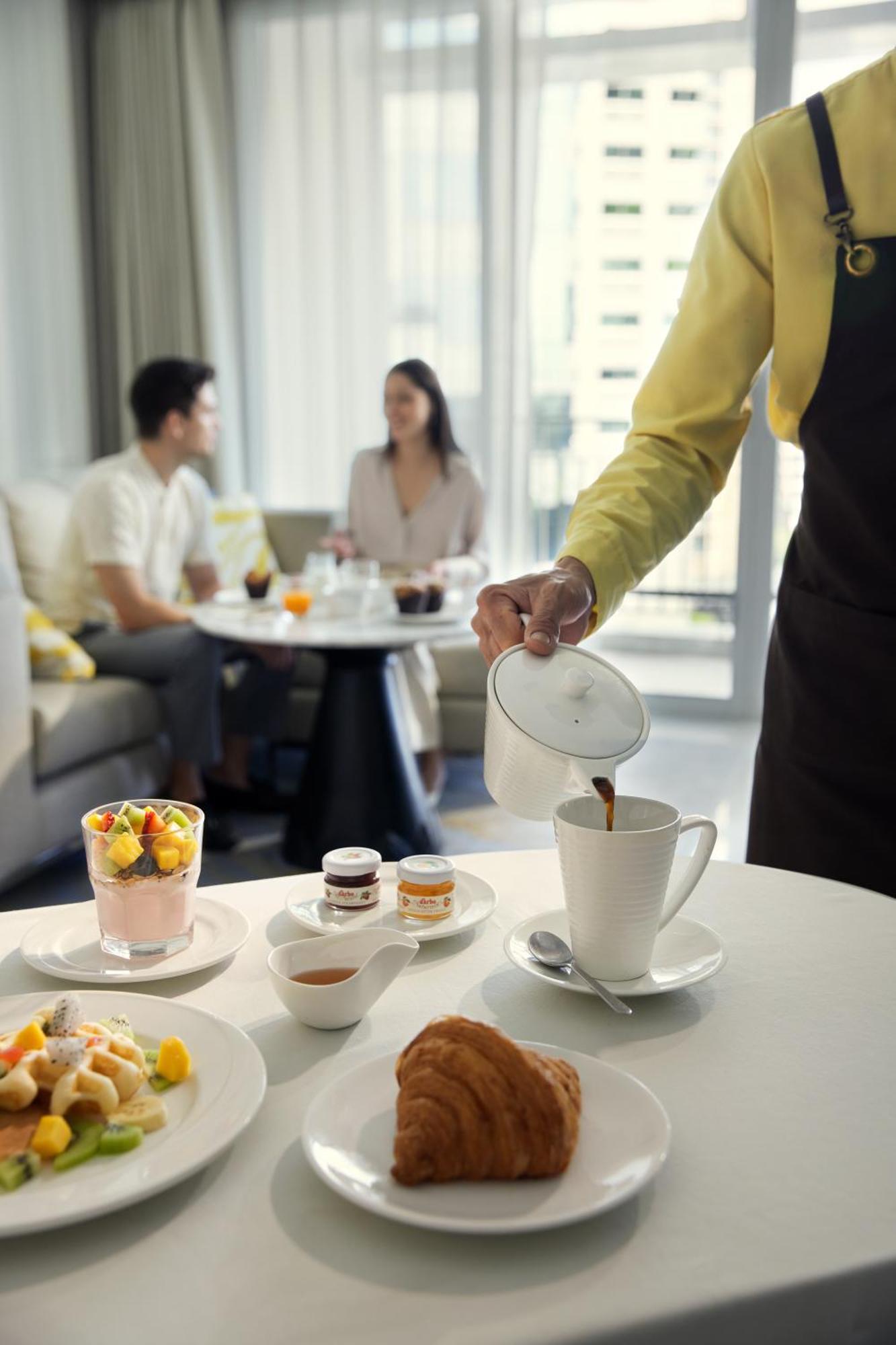 曼谷拉差达姆里都喜套房酒店 外观 照片 A waiter serving coffee