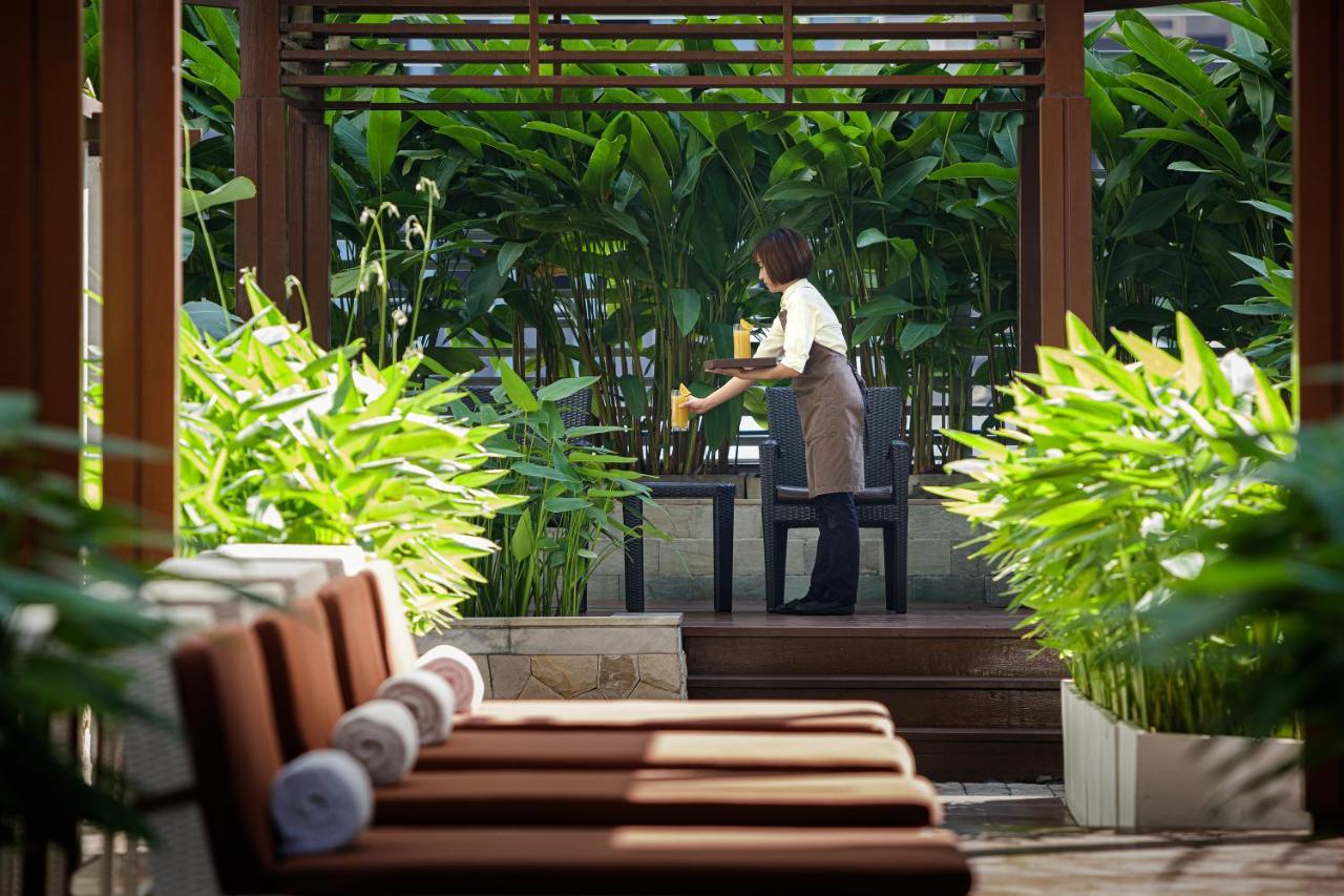 曼谷拉差达姆里都喜套房酒店 外观 照片 A hotel staff serving drinks at a resort